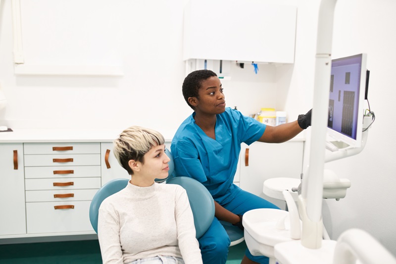 Dental hygienist and patient looking at a dental monitor