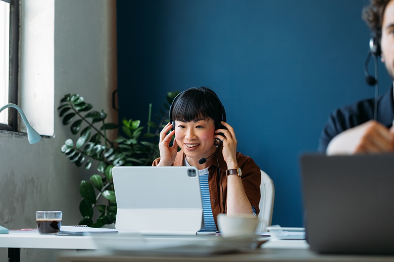 virtual assistant smiling at tablet wearing a headset