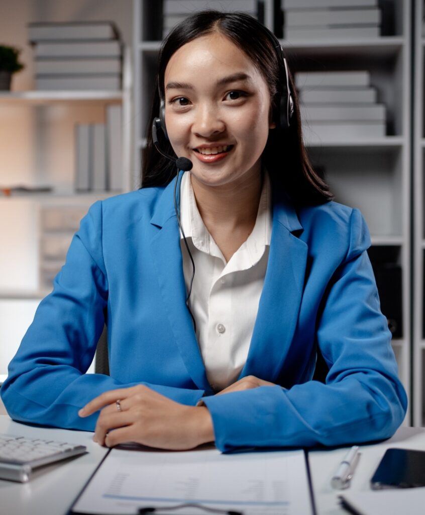 Asian woman wearing headphones and talking to customers. Call center employees answer the phone to help and answer questions from customers who call to use the service. Call center concept.