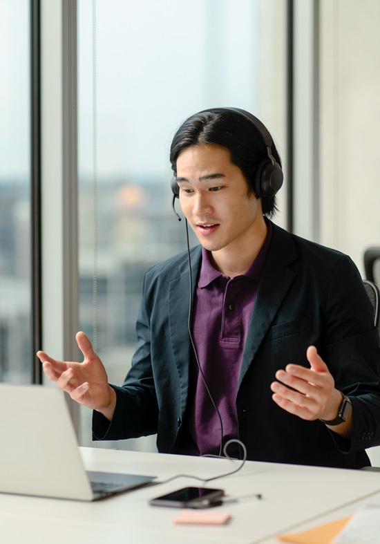 Young man wearing headset speaking in a video conference